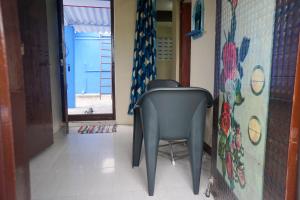 蓬蒂切里Villa Sea Blue - Homestay in Pondicherry的走廊上的椅子,带蓝色窗帘