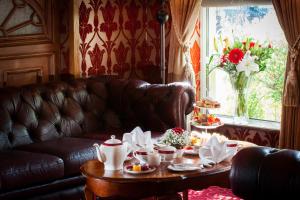 洛赫雷米多克特酒店的客厅配有真皮沙发和带餐具的桌子
