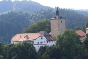 FürsteneckGroße Wohnung in Fürsteneck mit Grill und Terrasse的一座白色的大建筑,山上有塔