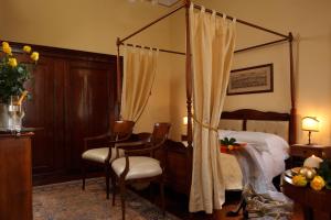 威尼斯佩西恩那阿卡德米亚玛拉维吉别墅酒店的一间卧室配有天蓬床和桌椅
