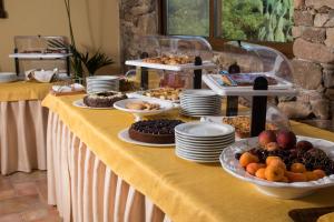 AnnunziataHotel I Menhirs的一张带黄色桌布食物的自助餐桌