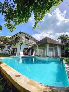 大雅台Kavanah Suites Tagaytay-Villa 3的一座大蓝色游泳池,位于房子前