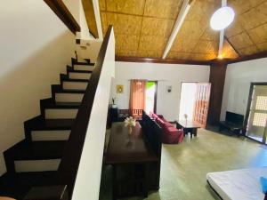 大雅台Kavanah Suites Tagaytay- Villa 2的一间带楼梯和沙发的客厅