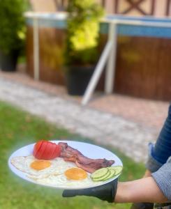 ľubochňaBudget izba pre veľkú rodinu alebo skupinu priateľov的持有鸡蛋培根和 ⁇ 菜盘的人