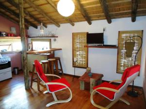 德尔迪阿布罗角艾伦德诺斯度假屋的一间带红色椅子的客厅和一间厨房
