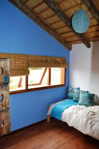 德尔迪阿布罗角艾伦德诺斯度假屋的蓝色墙壁间的一张床位