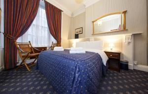 伦敦摄政大楼酒店的酒店客房,配有床和镜子