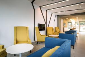 希欧福克健康及商务游艇酒店的一间设有蓝色和黄色椅子及桌子的等候室