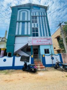 TirunallārTHIRUNALLAR S A RESIDENCY的两辆摩托车停在蓝色建筑前面