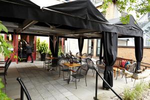 魁北克市圣日耳曼魁北克酒店的露台上配有一张黑伞,配有桌椅