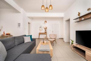 科斯镇New Modern Apartment in Kos Center的客厅配有灰色的沙发和电视