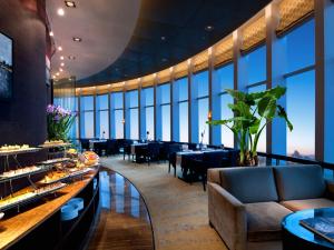 东莞HJ International Hotel的一间设有桌椅的餐厅,位于带大窗户的房间内
