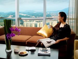 东莞东莞厚街国际大酒店 - 广交会期间免费穿梭巴士至展馆的坐在沙发上拿着一本书的女人