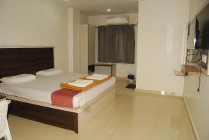 巴德拉恰拉姆Sri Kakateeya Grand Residency Bhadrachalam Hotel Residency Stay Rooms的一间卧室配有带毛巾的床