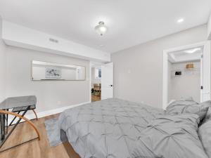 温莎Stylish 2-Bedroom Apartment In Downtown Windsor的白色卧室配有床和椅子