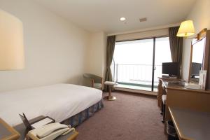 下关下关港市大酒店的酒店客房设有一张床和一个大窗户