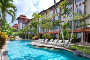 沙努尔巴厘岛总理大酒店 - 巴厘岛的酒店游泳池设有躺椅和棕榈树