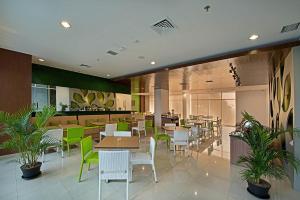 茂物微姿普莱姆帕加加阳博格尔酒店的一间设有桌椅的餐厅,种植了植物