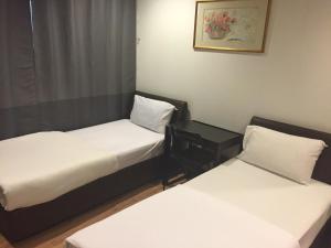 新加坡Hotel Conforto的配有白色床单的客房内的两张床