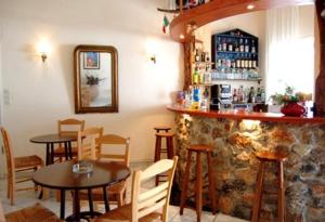 伊奥斯乔拉卢娜酒店的一间带桌椅的餐厅和一间酒吧