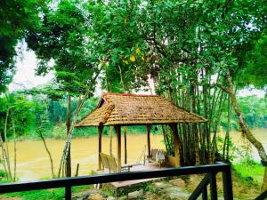 吉仙绿色希望旅馆 的河前的小小屋,配有桌椅