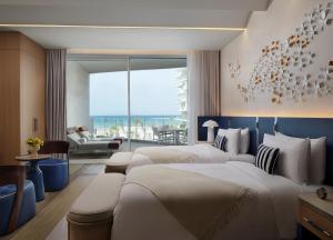 马斯喀特The St Regis Al Mouj Muscat Resort的酒店客房设有三张床,享有海景。