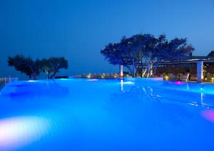 依拉佩特拉卡科斯海湾简易别墅酒店的夜间大型游泳池,灯光蓝色
