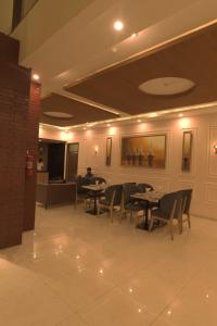 卡拉奇Signature Boutique Hotel Karachi的一间在房间内配有桌椅的餐厅