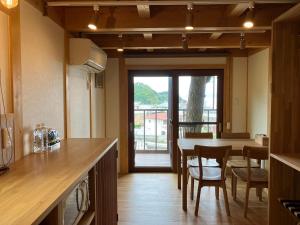 直岛町MY LODGE Naoshima的厨房以及带桌椅的用餐室。