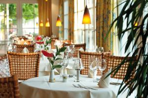 奥斯特西巴德钦诺维茨Hotel Kleine Strandburg - Adults Only的餐厅的桌子,配有白色桌布和酒杯