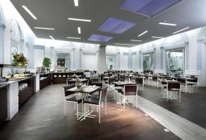 罗马埃克斯国际宫殿酒店的一间在房间内配有桌椅的餐厅