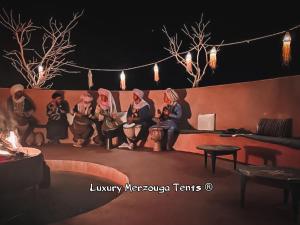 梅尔祖卡Luxury Merzouga Tents - Official的坐在舞台上的一群人