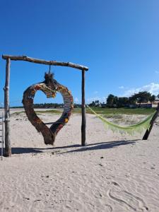 帕里普埃拉Pousada e Restaurante Mar dos Sonhos的一颗心挂在海滩上的杆上