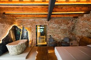 锡比乌World Studio Sibiu的一间砖墙内带浴缸的浴室的卧室