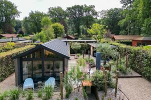 伊皮Modern ingericht chalet op groen park op de Veluwe的一座有温室的花园的形象