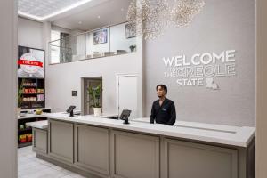 新奥尔良Hampton Inn & Suites New Orleans Canal St. French Quarter的坐在杂货店柜台上的人