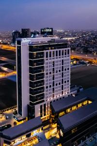 利雅德Radisson Hotel & Residence Riyadh Olaya的一座高大的白色建筑,有很多窗户