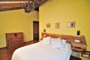 Monón科拉尔 - 阿尔迪乡村民宿的卧室设有白色的床和黄色的墙壁