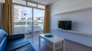 英格兰海滩Tagoror Beach Apartments - Adults Only的带沙发、电视和桌子的客厅