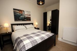 爱丁堡Hamish's Hame Edinburgh Licence No EH 69774 P的一间卧室配有一张床、两盏灯和一幅画