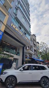 高平Hoa Việt Hotel的停在酒店前的白色汽车