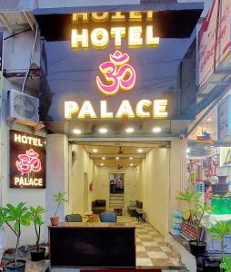 乌贾因HOTEL OM PALACE的带有酒店和宫殿标志的酒店入口