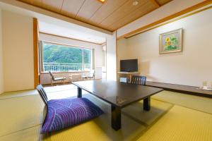 日光Ooedo Onsen Monogatari Hotel Kinugawa Gyoen的一间带桌子和窗户的用餐室