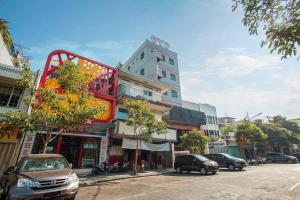 泗水OYO 491 Hotel Mata Air Tunjungan Surabaya的一条城市街道上一座高楼,有汽车停放