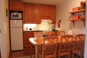 列维Levin Alppi 3 A 1 Apartment的厨房配有桌椅和冰箱。