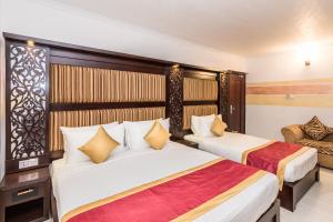 WatumullaMount Best Hotel- Mount Lavinia的酒店客房,配有两张床和椅子