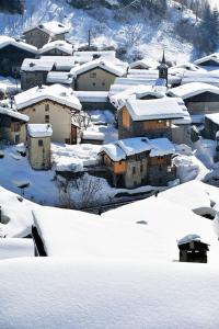 圣福瓦-塔朗泰斯Chez Michel的一座有房子和教堂的雪覆盖的村庄