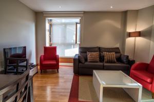 巴罗德亚尼斯信天翁公寓的客厅配有沙发和2把红色椅子