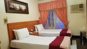 迪拜阿尔阿拉酒店的酒店客房设有两张床和窗户。