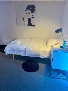 卡尔马Nice guest room apartment within walking distance to Kalmar central station的一间卧室配有一张床和一张桌子上的台灯